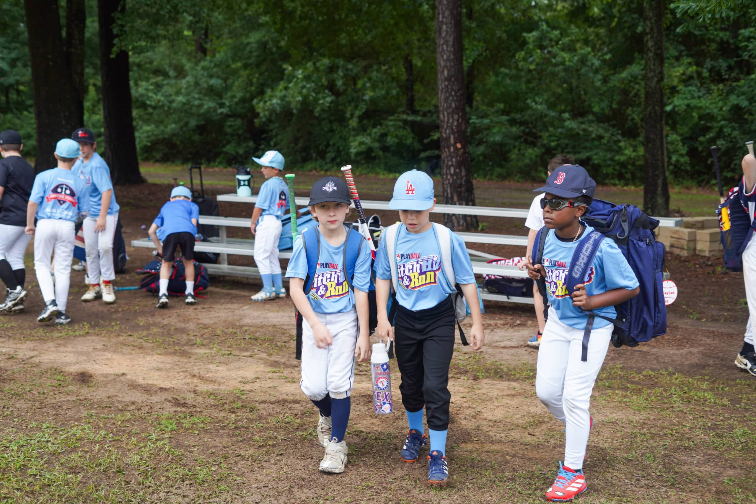 Kids in Pitch, Hit & Run jerseys walking onto the field at Justice Field.