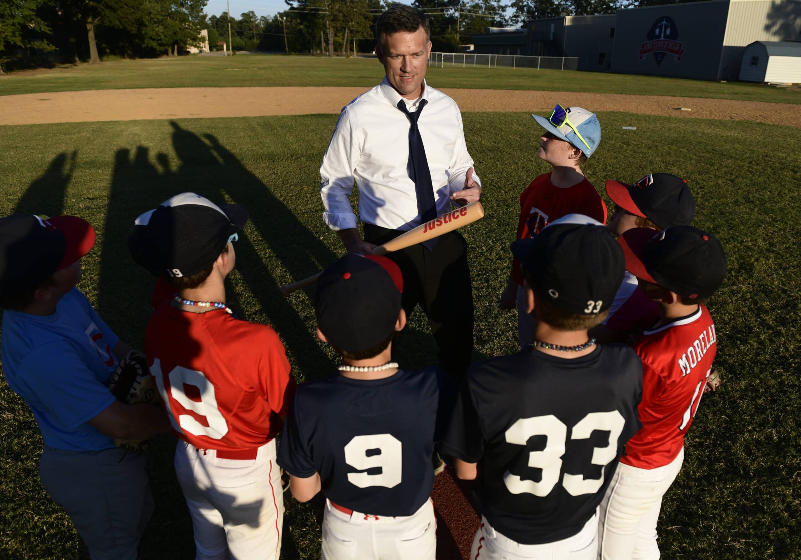 Scott, founder of Justice Field, talking with a huddle of young players on the field.